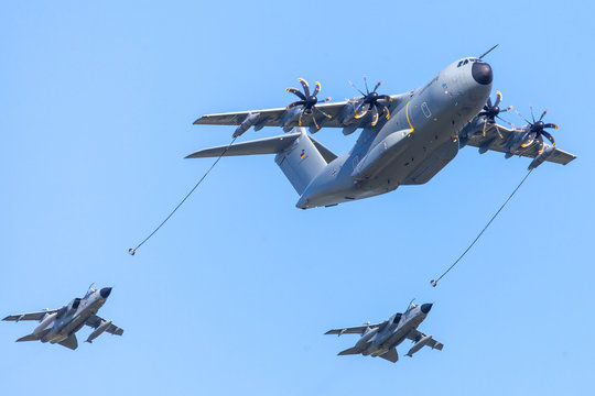 BERLIN / GERMANY - APRIL 28, 2018: Military Airbus A 400 M transport plane flies with two Panavia Tornado  multirole combat aircrafts at airfield Schoenefeld / Berlin.