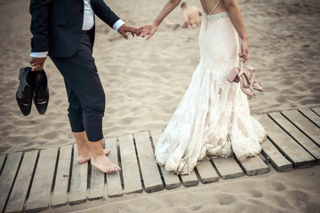 Young married couple holding hands, ceremony wedding day, wedding rings.