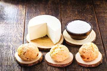 Brazilian cheese bread, hot, freshly made. Polvilho and Minas Gerais cheese in the background, on a rustic wooden box. Homemade, organic snack.