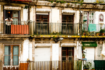Old woman or old woman going out to the balcony in Postcard of old doors and windows, in facades of decaying but happy buildings in Porto, Porugal
