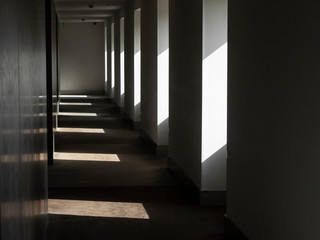 Pasillo interior del parador de Alcalá de Henares con las sombras que proyectan las ventanas