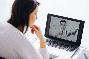 Handsome doctor explaining medical exam results to his patient over the internet conversation