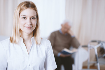 Beautiful young nurse with blonde hair and white uniform