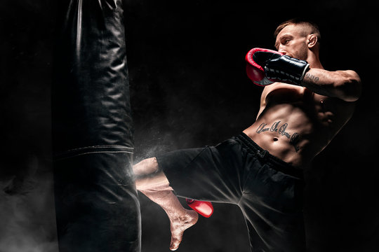 Kickboxer hits the bag with his knee. Training a professional athlete. The concept of mma, wrestling, muay thai.