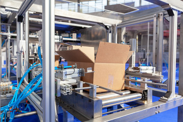 Automatic cardboard package box packaging machine in the empty factory. Financial crisis concept.