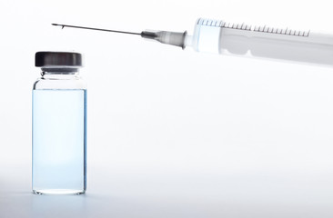 medical ampoule and syringe with blue transparent liquid on a white and gray background, gradient....