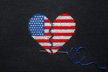 Broken heart of US flag colors embroidered on black canvas.