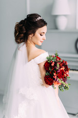 Portrait of a bride in a beautiful wedding dress with a wedding bouquet of peony roses