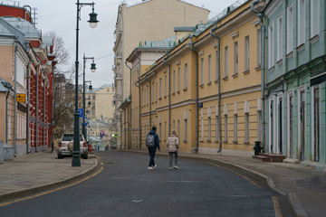 Obraz premium Almost no people at the streets in spring time. Couple of young man and woman. Concepts of social distancing, self-isolation. Coronavirus Pandemic lifestyles