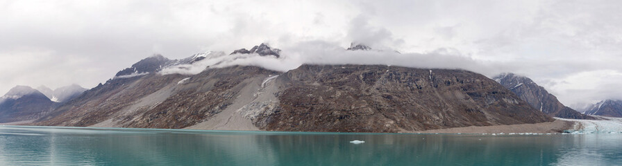 Greenland landscape with beautiful coloured mountains and iceberg.
