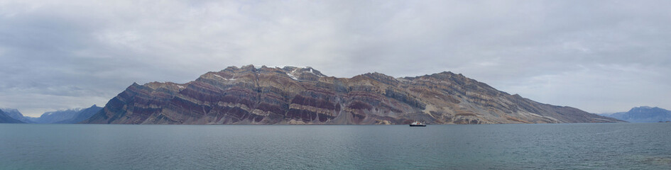 Greenland landscape with beautiful coloured mountains and iceberg.