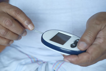 close up of senior man measuring diabetic.