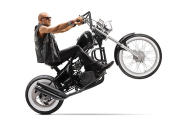 Fototapeta na wymiar Biker riding a chopper on one wheel