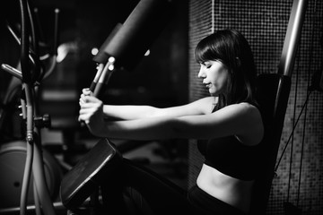 Woman doing fitness exercises on home gym chest press machine.Making an effort and training hard...