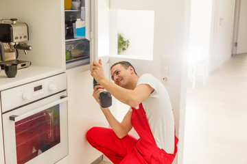 Repairman makes refrigerator appliance troubleshooting and maintenance works