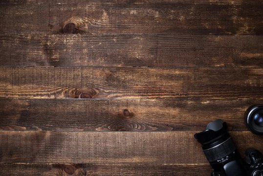 stop motion video of camera equipment being laid out on a dark wooden background with copy space 