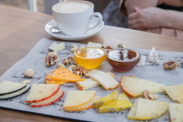cheese and nuts with honey on the Board. Cooking, food delivery, cafe, restaurant, cheese factory, cheese tasting.