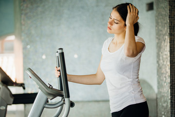 Woman doing fitness exercises on stepper at gym.Young woman making an effort and training hard for fit body.Excess body weight.Home aerobics workout.Effort,dedication and motivation concept