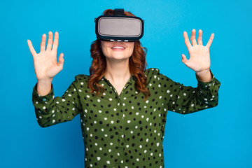 Photo of pretty crazy lady raise hands watch space galaxy planets show in vr box goggles try to touch cosmic ship wear green dotted shirt isolated blue color background