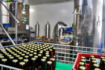 Selective focus on a group of capped beer bottles in a brewery ready to be distributed in boxes