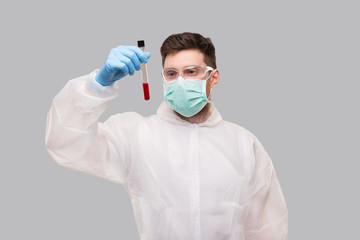 Male Laboratory Worker Checking Blood Analysis Wearing Medical Mask, Gloves and Chemical Suit. Virus, Science Concept Portrait