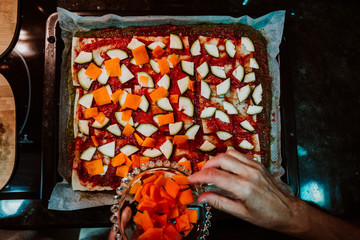 .Middle-aged woman preparing a healthy pizza based on fresh food. Cooking at home relaxed and unhurried. Stay home