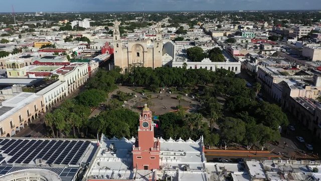 Slow fly over the Merida city hall, zocalo or plaza grande to the cathedral San Ildefonso in Merida, Yucatan, Mexico.