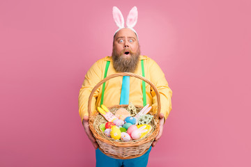 Portrait of his he nice amazed impressed funky glad bearded guy holding in hands giving you festal Easter craft basket bakery snack isolated over pink pastel color background