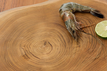 Fresh prawn and lime on a wooden background. Kitchen Background.