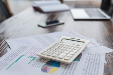 Calculator with papers on table in office