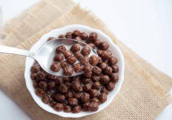 Chocolate balls with milk and a spoon in a white plate
