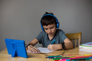 Caucasian boy studies online during coronavirus  school lockdown.