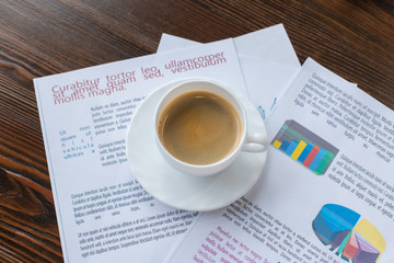 High angle view of cup of coffee on papers on table