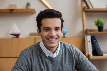 Portrait of businessman smiling and looking at camera in office