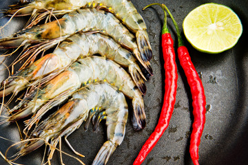 Fresh shrimp in a pan with red chili pepper and Lemon. Close-up. Kitchen background.