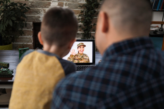 Military family video chatting at laptop