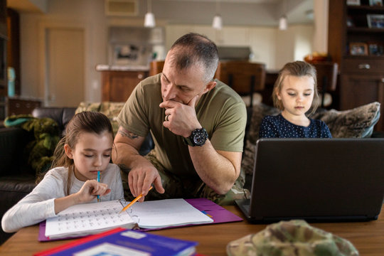 Soldier father helping daughter with homework