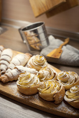 Close up of delicious croissants and pastries with apples, on a wooden Board in a cafe