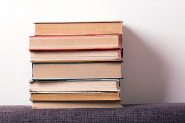 Stack of old books on the back of the sofa
