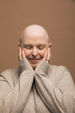 Portrait Of Carefree Bald Woman With Alopecia And Head In Hands