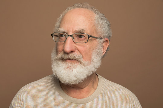 Portrait Of Thoughtful Senior Man With Curly Gray Hair And Eyeglasses