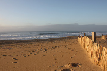 Empty wide beach on sunset with footprints and driftwood fence - Large plage vide avec empreintes...