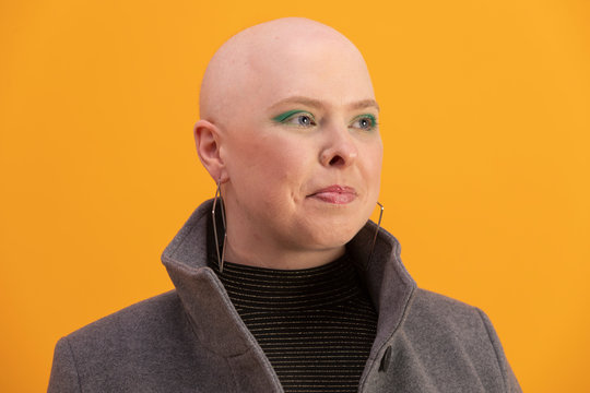 Portrait of confident bald woman with alopecia in green eyeshadow