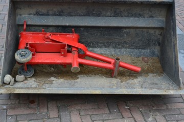 old rusty tractor on a farm with red stone cutter