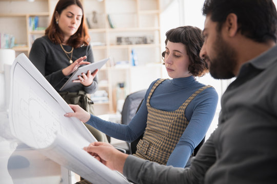 Architects Discussing Plans In Studio