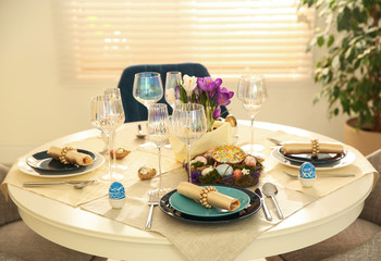 Festive Easter table setting with decorated eggs in kitchen