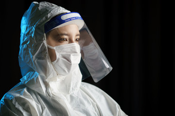 Woman wearing gloves, biohazard protective suit, face shield and mask. For corona virus or Covid-19...