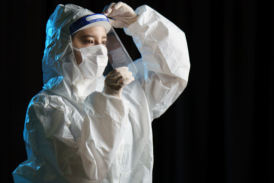 Woman Wearing Gloves, Biohazard Protective Suit, Face Shield And Mask. For Corona Virus Or Covid-19 Protection.