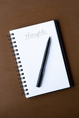 Notebook with Thoughts and Pen