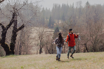 Loving couple walking on the mountain outdoors. Man and woman travel together. Couple traveler enjoys nature, hugs,